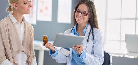 Doctor and patient discussing something while sitting at the table . Medicine and health care conceptの写真素材