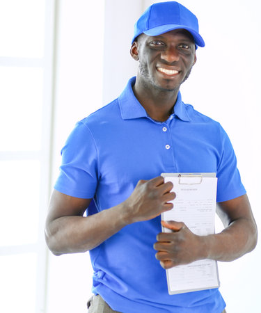 Portrait of an handsome happy deliverer with folderの写真素材