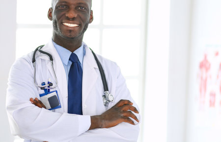 Happy afro man doctor portrait with arms crossedの写真素材