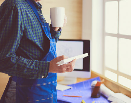 Architect working on drawing table in officeの写真素材