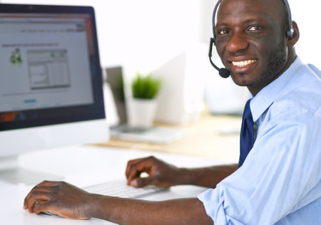 African american businessman on headset working on his laptopの写真素材