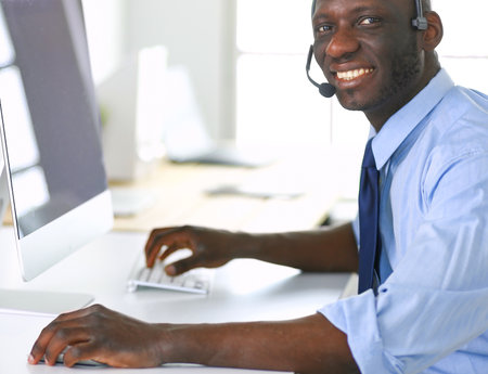 African american businessman on headset working on his laptopの写真素材