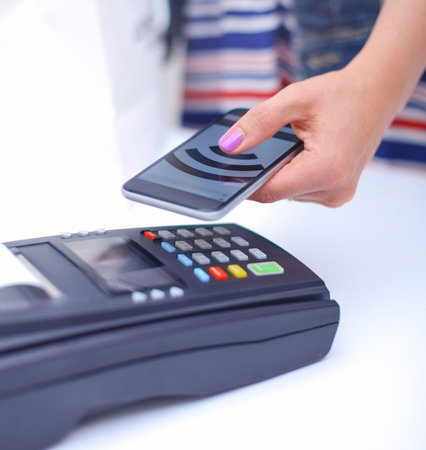 Customer is paying with smartphone in shop using NFC technology. NFC technology. Customer is payingの写真素材