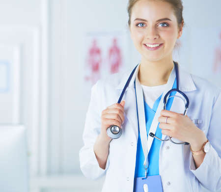 Portrait of young woman doctor with white coat standing in hospitalの写真素材