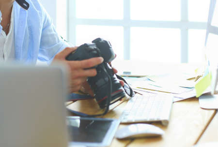 Portrait of young designer sitting at graphic studio in front of laptop and computer while working online.の写真素材