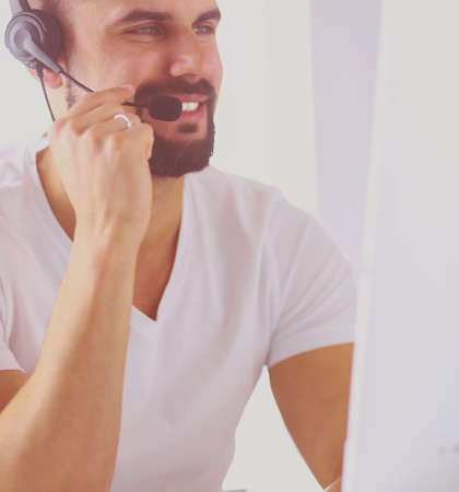 Portrait of a young man with a headset in front of a laptop computerの写真素材