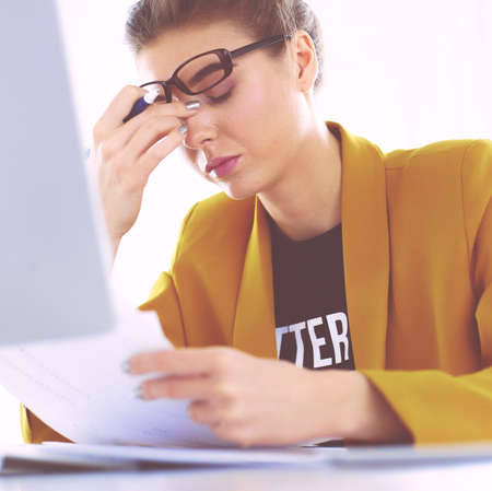 Portrait of a young tired businesswoman using laptop and workingの写真素材