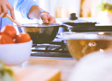 Man preparing delicious and healthy food in the home kitchenの写真素材