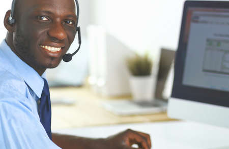 African american businessman on headset working on his laptopの写真素材