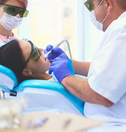 Portrait of a dentist who treats teeth of young woman patientの写真素材