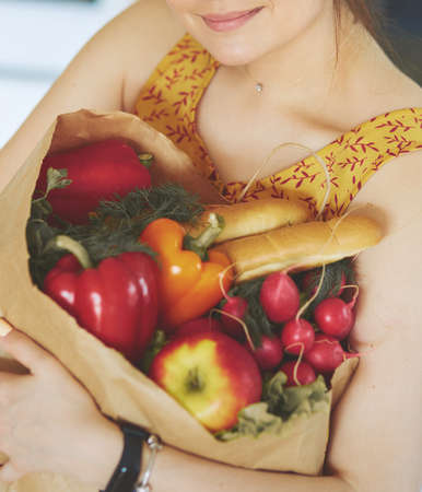 Young woman holding grocery shopping bag with vegetablesの写真素材