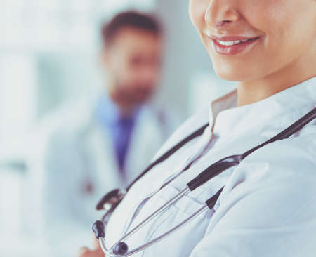 Woman doctor with stethoscope standing with arms crossedの写真素材