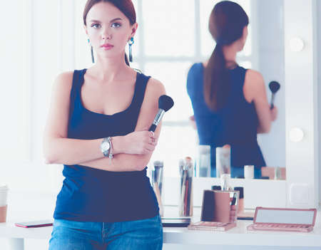 Beautiful girl with cosmetic powder brush for make up. Makeup. Make-up applying for perfect skinの写真素材