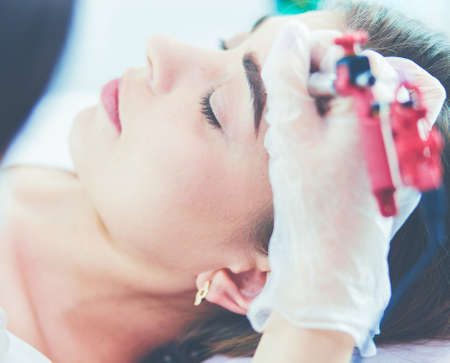 A young girl having red lips permanent makeup, micropigmentationの写真素材