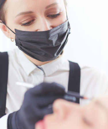 Cosmetologist applying permanent make up on eyebrowsの写真素材