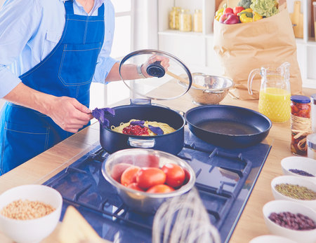 Man preparing delicious and healthy food in the home kitchenの写真素材