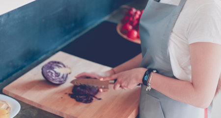 Young woman using a tablet computer to cook in her kitchenの写真素材
