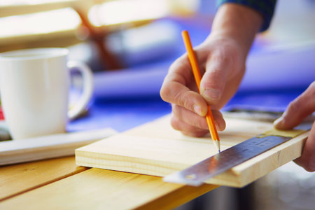 Architect working on drawing table in officeの写真素材