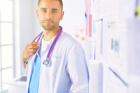 Young and confident male doctor portrait standing in medical officeの写真素材