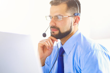 Businessman in the office on the phone with headsetの写真素材