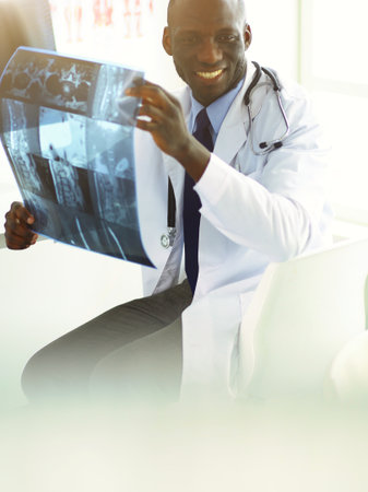 Portrait young african medical doctor holding patients x-rayの写真素材