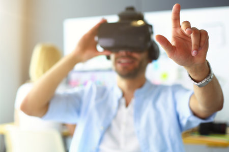 Young male software programmer testing a new app with 3d virtual reality glasses in office.の写真素材