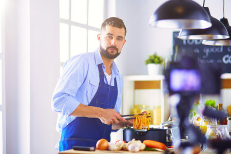 Man holding paper bag full of groceries on the kitchen background. Shopping and healthy food conceptの写真素材