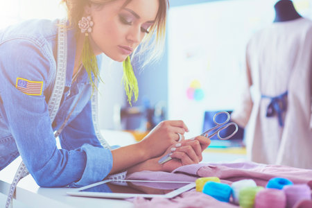 Fashion designer woman working with ipad on her designs in the studioの写真素材