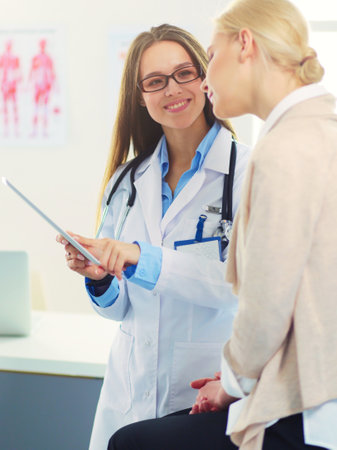 Doctor and patient discussing something while sitting at the table . Medicine and health care conceptの写真素材