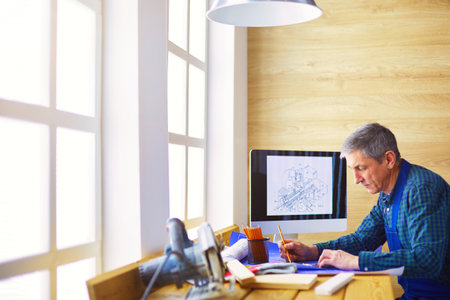 Architect working on drawing table in officeの写真素材
