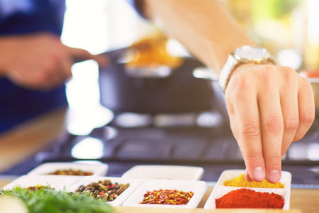Man preparing delicious and healthy food in the home kitchenの写真素材