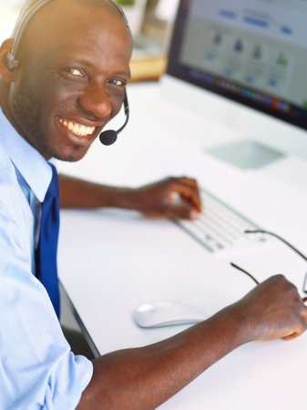 African american businessman on headset working on his laptopの写真素材