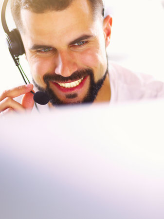 Portrait of a young man with a headset in front of a laptop computerの写真素材