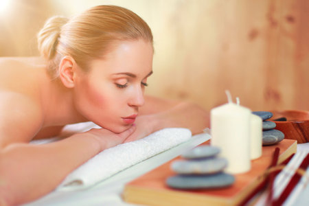 Beautiful young woman getting spa massage, lying on salonの写真素材