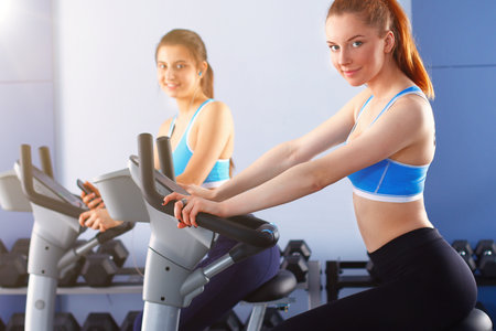 Group of people at the gym exercising on cross trainersの写真素材