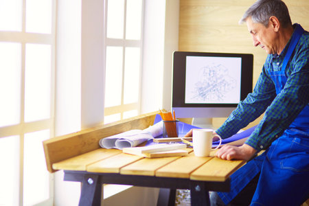 Architect working on drawing table in officeの写真素材