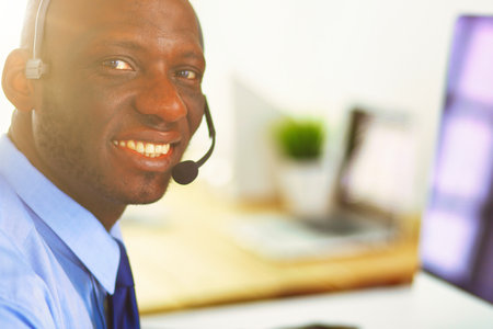 African american businessman on headset working on his laptopの写真素材