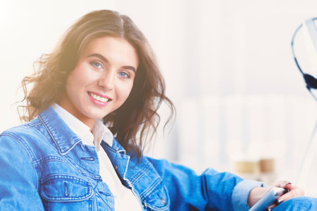 Image of a confident young woman sitting at working deskの写真素材