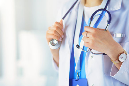 Woman doctor standing with stethoscope at hospitalの写真素材