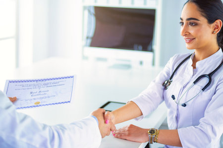 Doctor shakes hands with a patient isolated on white backgroundの写真素材