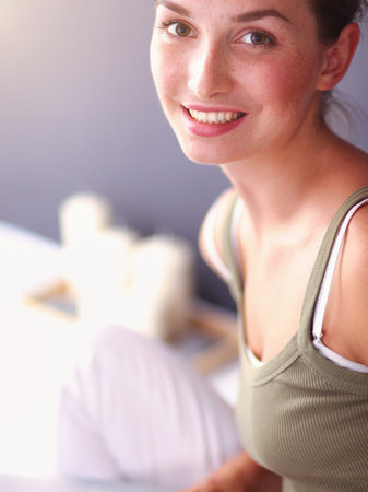Attractive caucasian girl sitting on floor with cup and tablet near wallの写真素材
