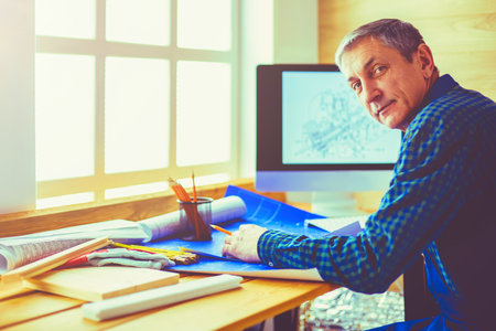Architect working on drawing table in officeの写真素材