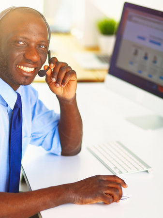 African american businessman on headset working on his laptopの写真素材