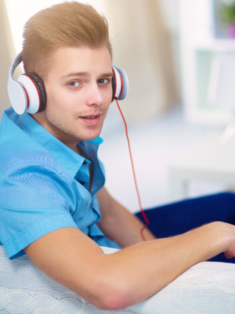 Man listening music with headphones at homeの写真素材