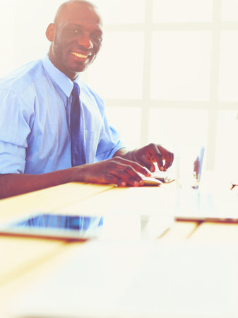 African american architect working with computer and blueprints in officeの写真素材