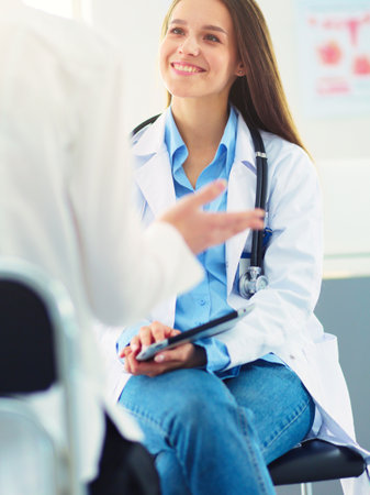Doctor and patient discussing something while sitting at the table . Medicine and health care conceptの写真素材