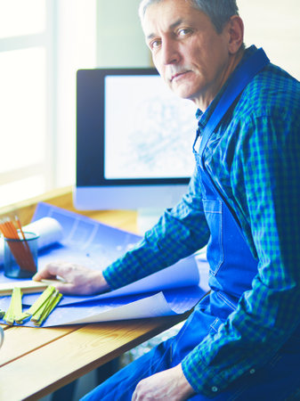 Architect working on drawing table in officeの写真素材