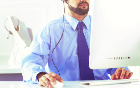 Businessman in the office on the phone with headsetの写真素材
