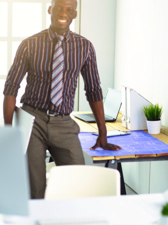 African american architect working with computer and blueprints in officeの写真素材