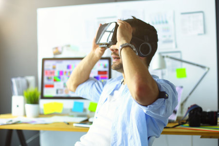 Young male software programmer testing a new app with 3d virtual reality glasses in office.の写真素材